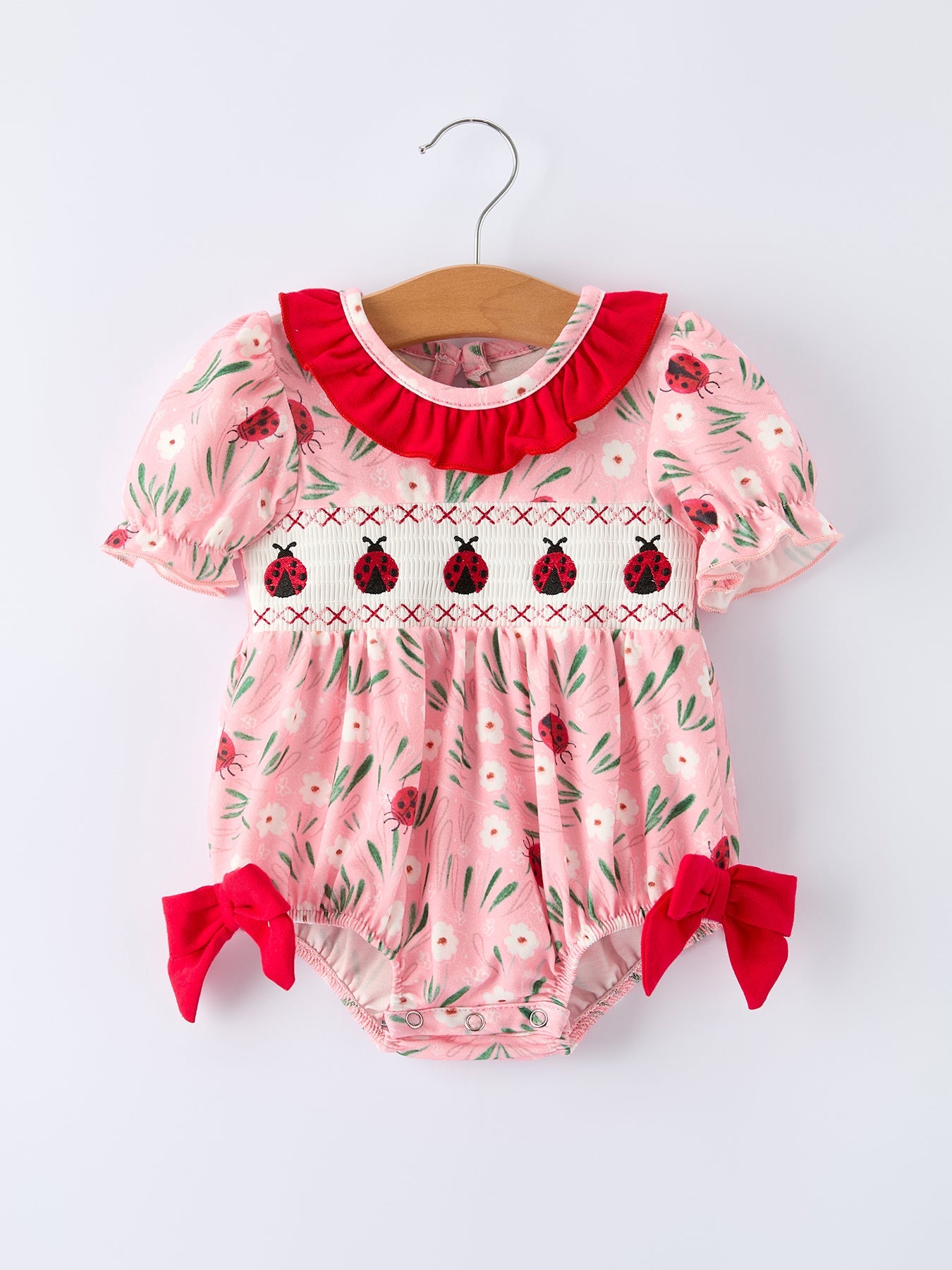 Mono de bebé niña con bordado fruncido y mariquita de primavera