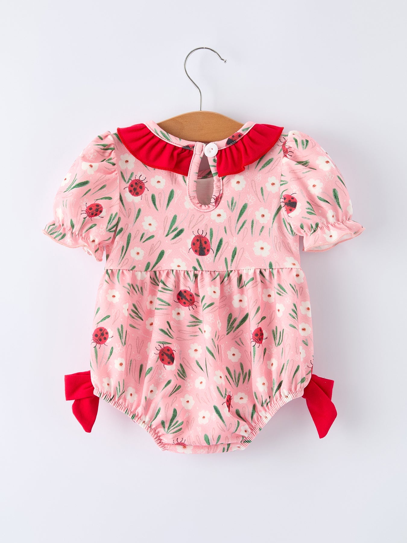 Mono de bebé niña con bordado fruncido y mariquita de primavera
