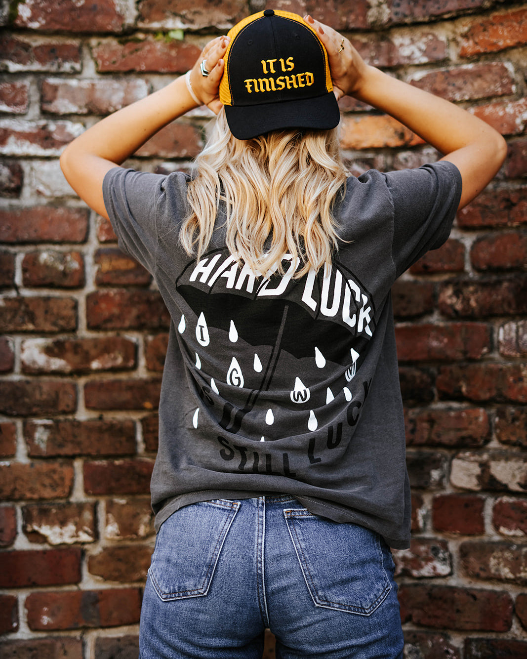 Gorra snapback negra y amarilla con la frase "It Is Finished"