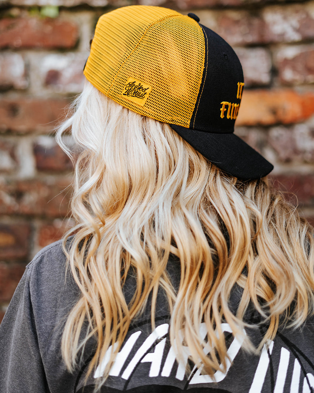 Gorra snapback negra y amarilla con la frase "It Is Finished"