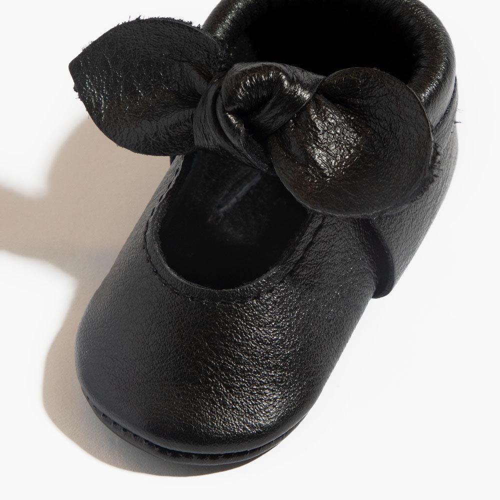 Zapato de bebé con lazo anudado de ébano